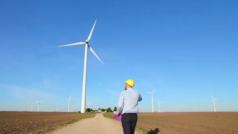 Power engineer is walking near windmills. Stock-Footage 76548670