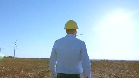 Power engineer is walking near windmills. Stock-Footage 76599945
