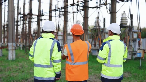 Power engineers are discussing the work plan. Three engineer standing with Stock Footage 194618752