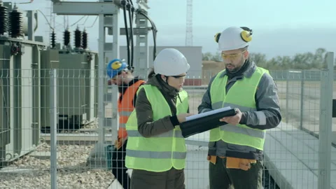 Power engineers man and lady in helmets discuss project Stock Footage 142969220