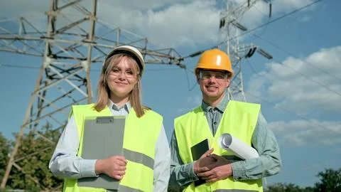 Power engineers posing for camera during inspection of electricity pylons Stock-Fotos