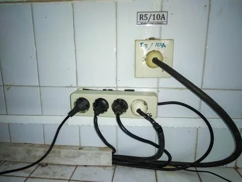 Power extension cable is fully loaded with electronic equipment cables Stock Photos