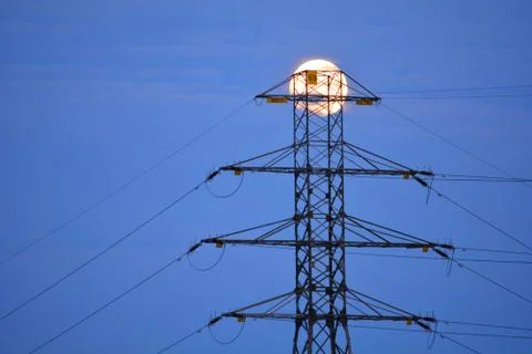 Power grid pylon with a full moon in the background Stock Photos