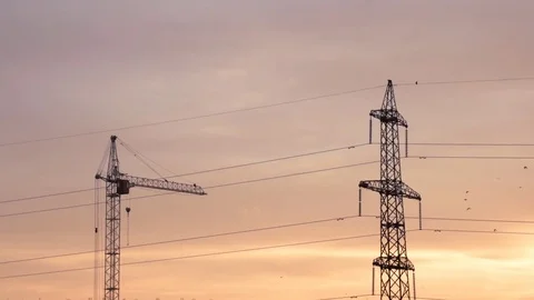 Power line, construction crane and birds with creamy colorful sky in the morning Stock Footage 80337672