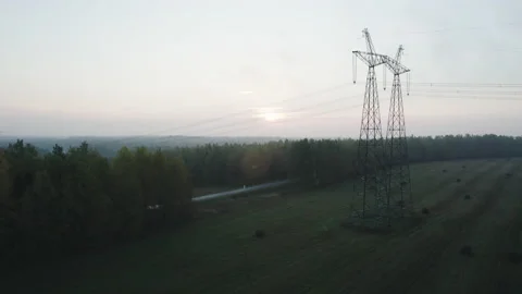Power line support with high voltage wires in a wooded area. Vídeo Stock 165292995