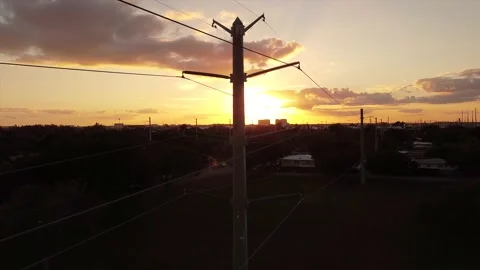 Power Lines aerial DOWN over sunset sunrise silhouette power grid wires Video stock 221264315