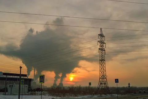 Power lines against the backdrop of sunset and smoke from a thermal power plant Stock-Fotos