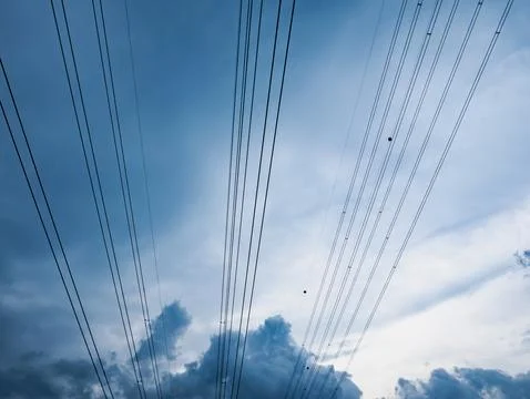 Power Lines Against Dramatic Cloudy Sky Minimal Blue Sky Background Stock Photos