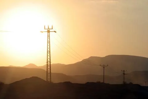 Power lines and array of electric pylons in Judea desert Stock Photos