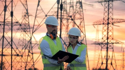 Power lines and two specialists engineers working on renewable energy Stock Footage 101198777