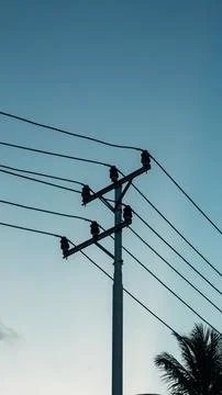 Power Lines and Utility Pole Against a Clear Blue Sky Stock Photos
