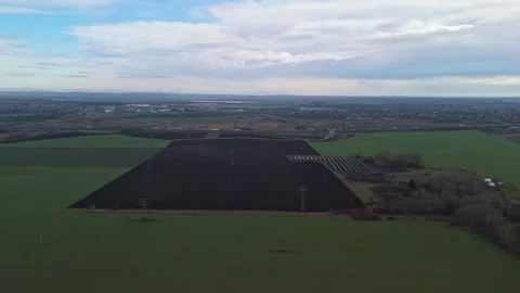Power lines cross flat farmland near miskolc under an overcast winter sky Stock Footage 336506138
