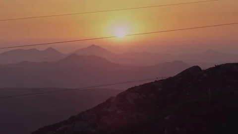 Power lines cross a mountain view sunset Vídeo Stock 100193409