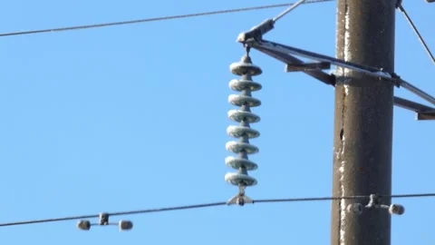 Power lines with insulators in cold weather showing the clear sky above the land Stock Footage 328438814