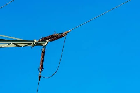 Power lines with insulators under clear blue sky. Stock Photos