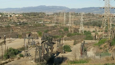 Power lines over oil fields.  pumps are running. Stockbeeldmateriaal 112856233
