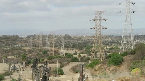 Power lines over oil fields.  pumps are running. Stock Footage 119077697