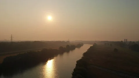 Power lines over river with sun in background Stock Footage 115079677