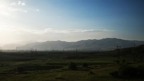 Power lines on the plain, mountains in the background, Foto stock