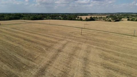 Power lines running across farm fields England drone aerial view Stock Footage 205593659