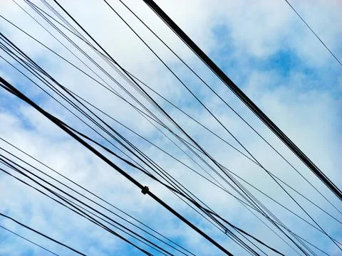Power Lines Silhouette Against Blue Sky Background Stock Photos