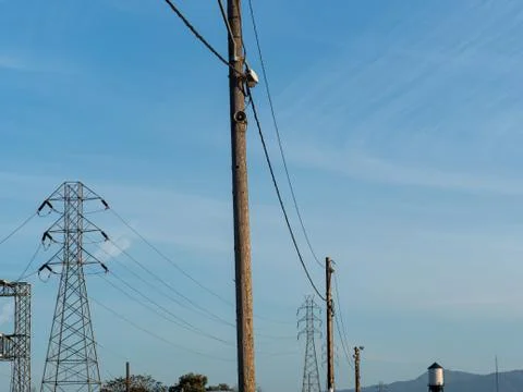 Power lines stand high while stretching in the horizon Stock Photos