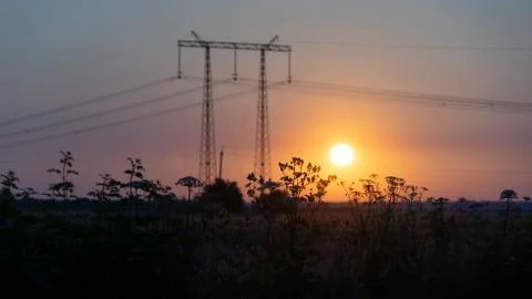Power lines at sunset in the field Stock Photos
