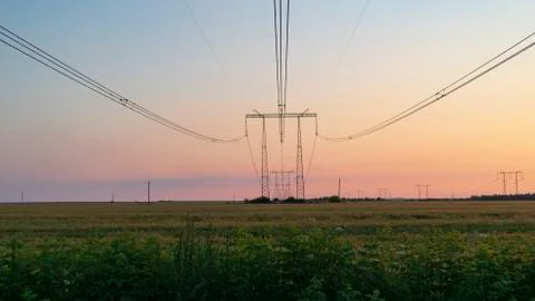 Power lines at sunset in the field Stock Photos