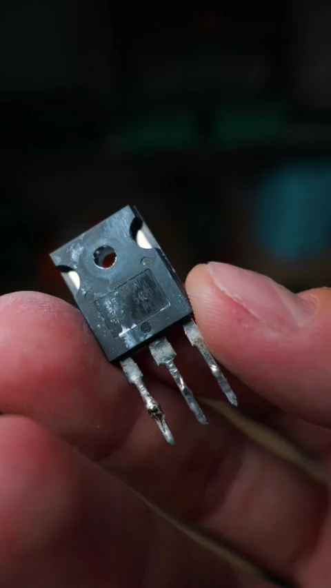 Power Mosfet Transistor Held in Hand for Inspection Inside Dark Workshop Stock Footage 339364994