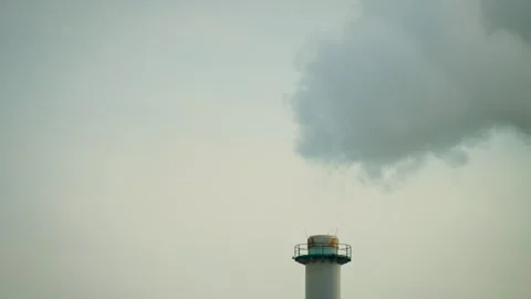 Power plant stack with dense smoke billowing aggressively upward. Industrial 库存影片 334663149