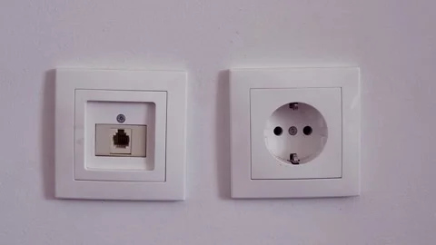 Power plug and a socket for internet cable side by side on a wall. Stock Footage 272985996