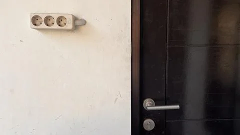 Power plug and socket stuck to the wall. Stock Photos