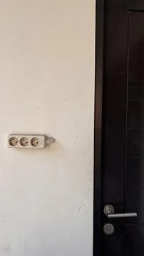 Power plug and socket stuck to the wall. Stock Photos