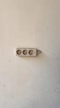 Power plug and socket stuck to the wall. Stock Photos