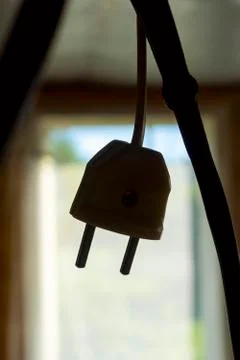 Power plug on electrical wire dangles by the doorway indoors Фото