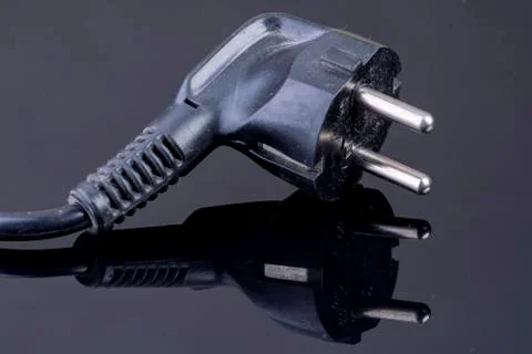 Power plug on reflective black surface Stock Photos
