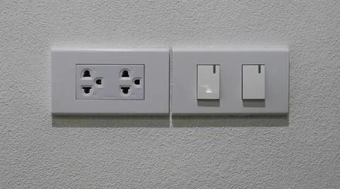 Power plug, separate light switch, white cement wall Stock-Fotos