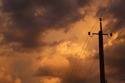 Power pole on the background of yellow clouds 写真素材
