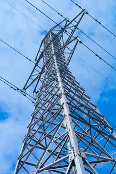 Power pole with high voltage against the blue sky Stock Photos