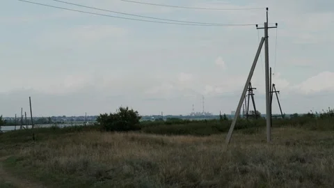 Power poles standing in an open grassy field under cloudy skies. Stock Footage 342949366