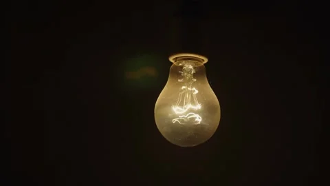 Power saving concept. Light bulb turns on and off over black background Stock Footage 273495958