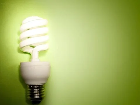 Power saving light bulb on green Stock Photos