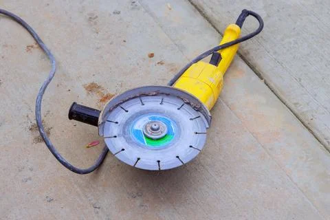 Power saw tool rests on cement slab after use at construction site Stock Photos