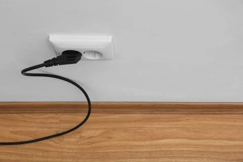 Power socket and plug on wall indoors, space for text. Electrician's equipmen Stock Photos