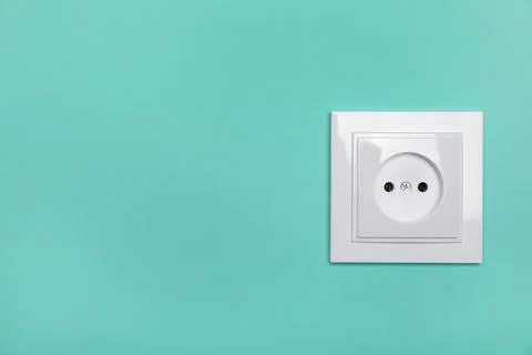Power socket on turquoise wall, space for text. Electrical supply Foto stock