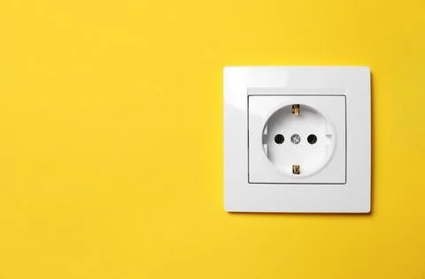 Power socket on yellow wall, space for text. Electrical supply Foto stock