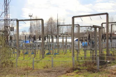 The power station. High voltage structures on green grass. Cables, wires and Foto stock