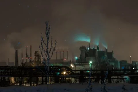 Power station with steam cloud blown by the wind in a cold starry winter nigh Stock Photos