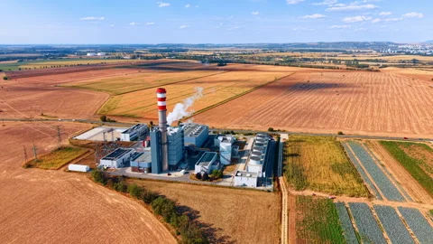 Power station within a patchwork of agricultural fields. A compact industrial Stock Footage 346483606