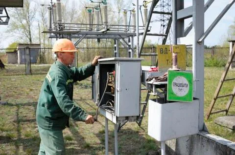 At the power substation. Worker checking connections on the electric board Stock Photos
